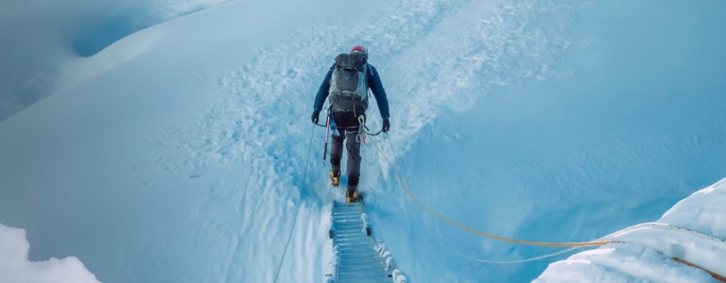 Esports d´aventura: alpinista al mig de la muntanya nevada